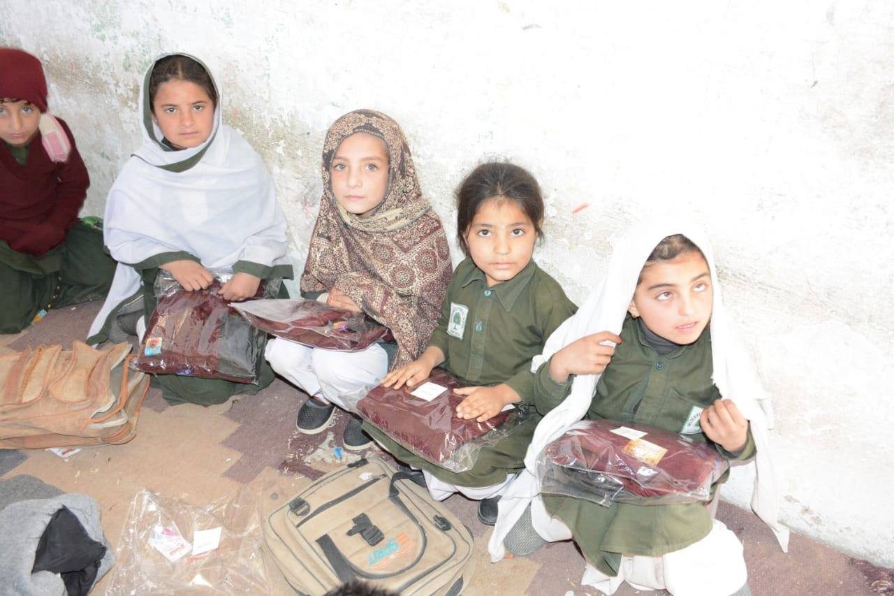 Girls in green uniforms with their new school bags