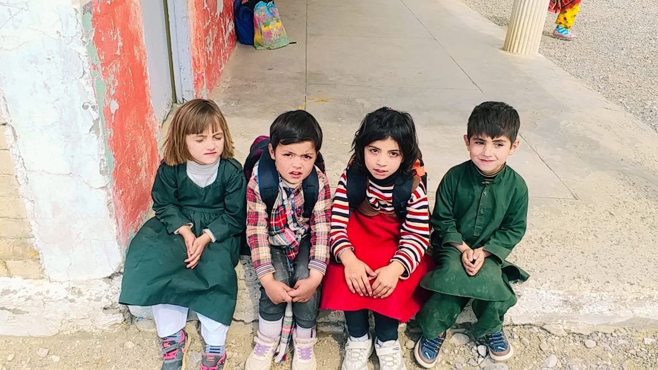 Four young students sitting together at the school